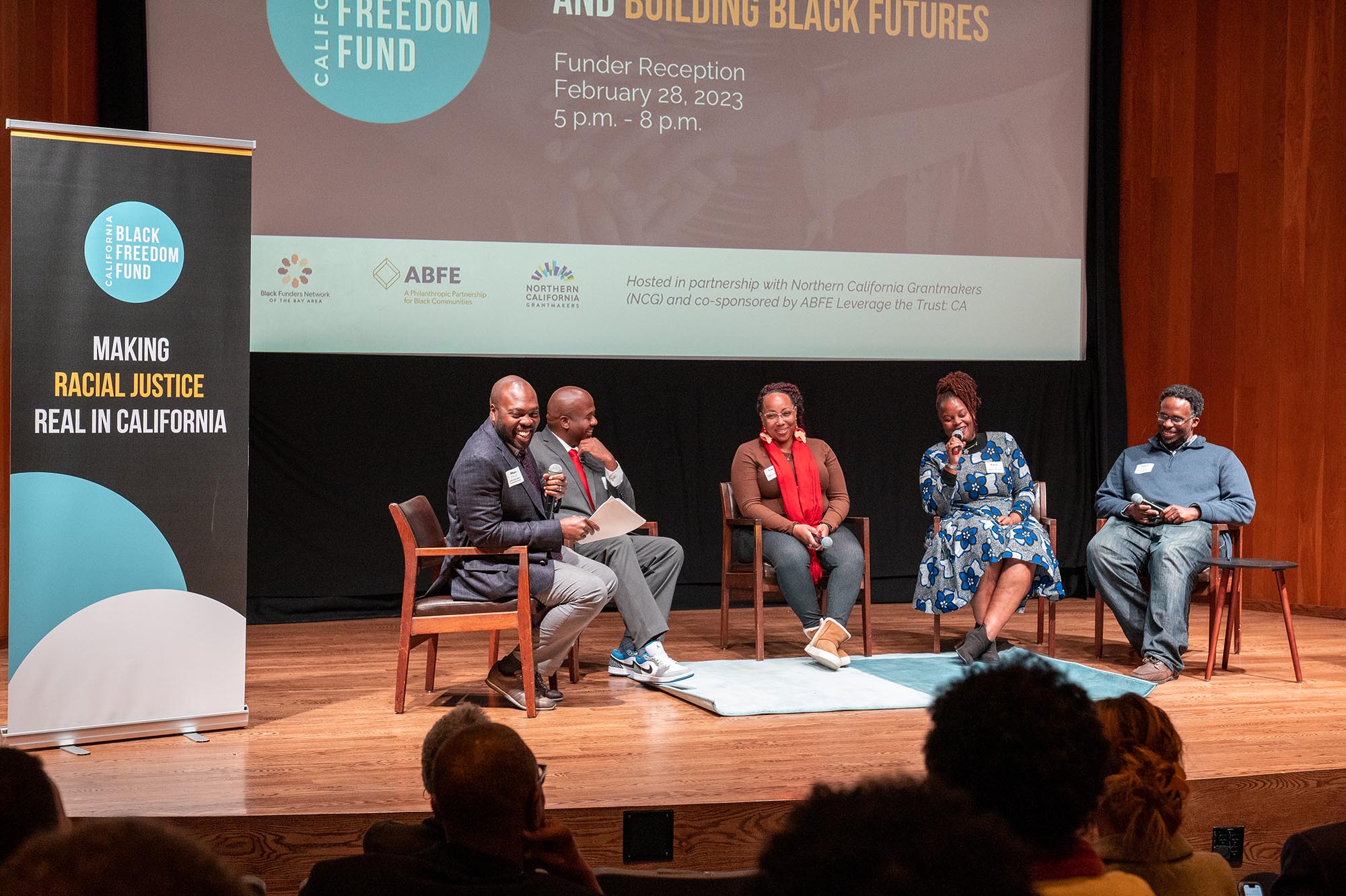 Group of black people talking and laughing on stage