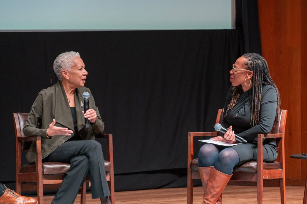 two black women speaking together on stage