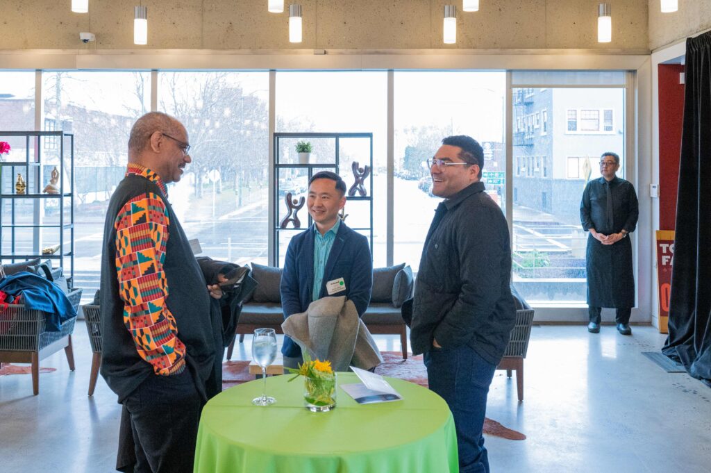 three men talking around a table