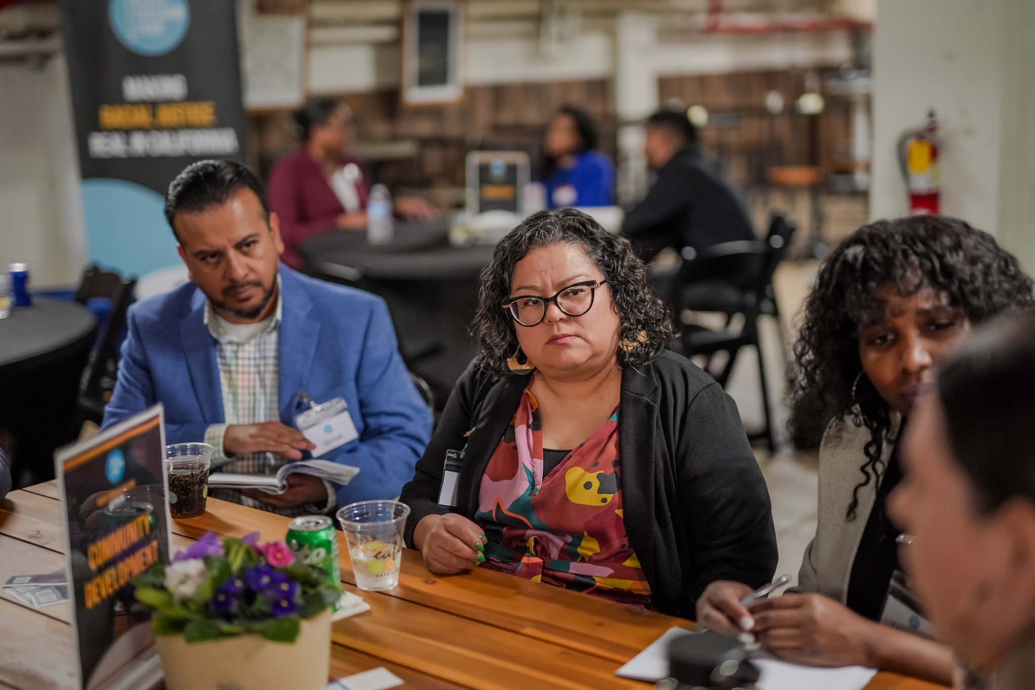 people seated at a table talking at Fresno Black Pow(Her) Building Event