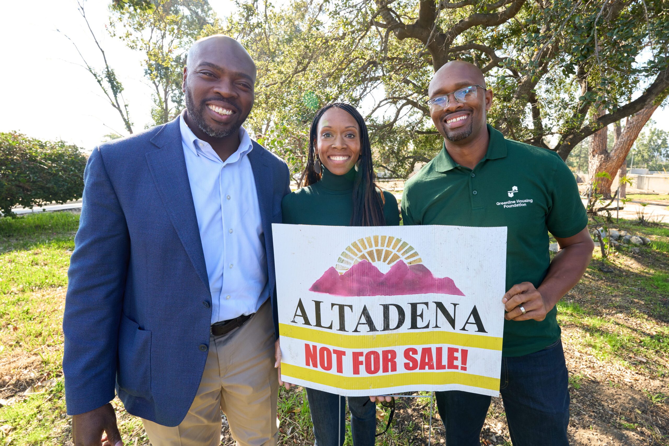 photo by Leroy Hamilton. Photo of three people standing closely together, smiling while looking into the camera and holding a sign that reads: Altadena not for Sale