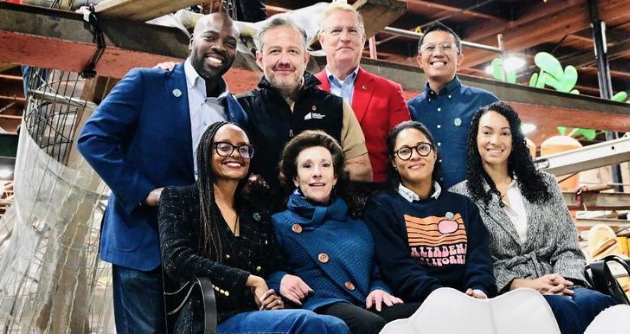 Back row left to right: Marc Philpart, president BFF; Miguel Santana, president CCF; Mark Leavens, president, Tournament of Roses; Andrew King. Front row left to right: Jacque Baisley Robinson, Eaton Fire survivor; Myra Burg, Palisades Fire survivor; Shimica Gaskins, Eaton Fire survivor; Gina Clayton Johnson, Eaton Fire survivor on the “Rising Together” float in the AES Float Barn at the Rosemont Pavilion in Pasadena