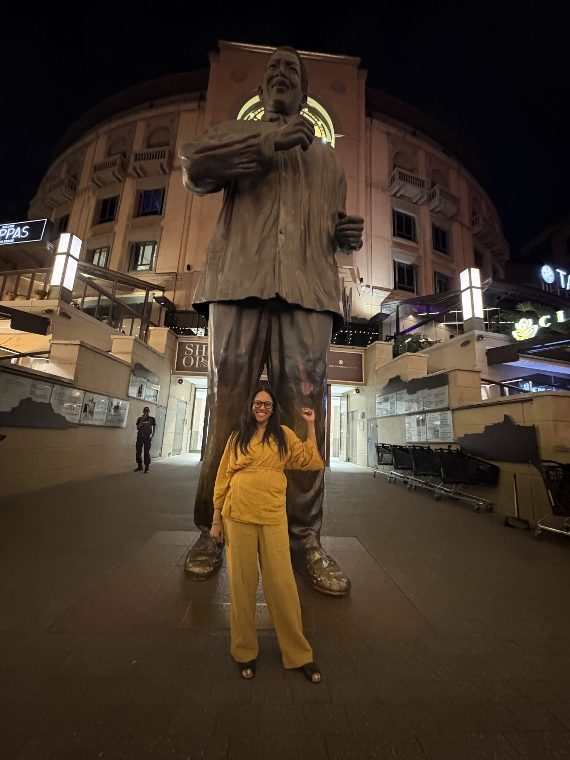 2025 Okobi Sabbatical participant, Shimica Gaskins, standing in front of a statute of Nelson Mandela